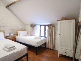 A bedroom with two beds and a wardrobe at 1 Fron Uchaf in Parc near Bala