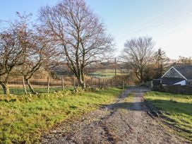 A gravel path leading to a house surrounded by trees at 1 Fron Uchaf in Parc near Bala