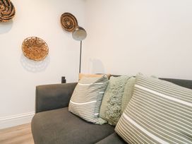 A sofa with cushions and wall decor at Klysa in Camborne