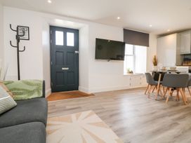 A living room with a sofa and dining area at Klysa Camborne