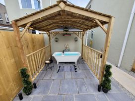 An outdoor area with a bathtub and wooden structure at Klysa in Camborne