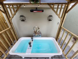 An outdoor bathing area with a bathtub and decorative fixtures at Klysa, Camborne