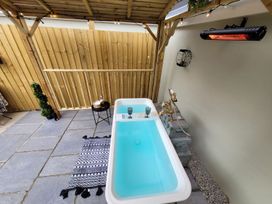 An outdoor bath area with a bathtub and a small table at Klysa in Camborne
