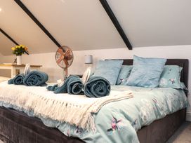 A bedroom with a bed, towels, and a fan at Thomas Chambers in Camborne