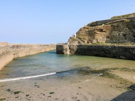 A coastal area with water and stone walls at Thomas Chambers in Camborne