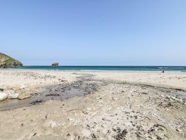 A beach with sand and water at Thomas Chambers in Camborne