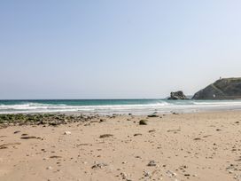 A beach with waves and rocks at Thomas Chambers in Camborne