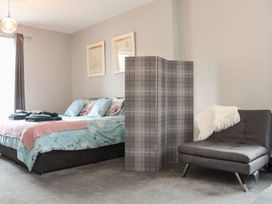 A bedroom with a bed and a chair at West Chambers in Camborne
