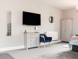 A bedroom with a television and dresser at West Chambers in Camborne
