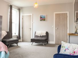 A living room with two chairs and a picture at West Chambers in Camborne