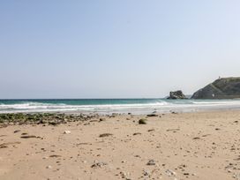 A beach with sand and rocks alongside the ocean at West Chambers in Camborne