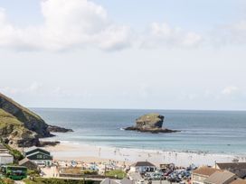 A beach with people and a rock formation at West Chambers in Camborne