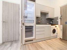 A kitchen with a refrigerator and washing machine at Baker Chambers in Camborne