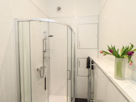 A shower with a towel rack and a plant in a vase at Baker Chambers in Camborne