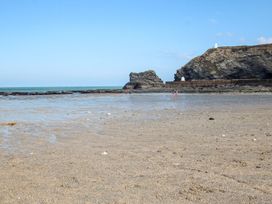 A beach with sand and rock formations at Baker Chambers in Camborne