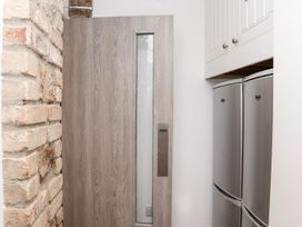 A kitchen with a door and refrigerator at Teylu in Camborne