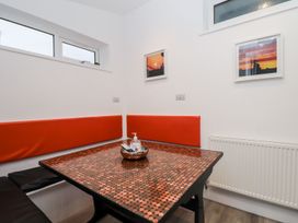 A dining room with a table and bench seating at Teylu in Camborne
