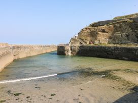 A view of a harbor with water and rock formations at Teylu in Camborne