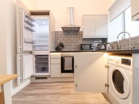 A kitchen with appliances including a refrigerator and washing machine at Battell Chambers Camborne