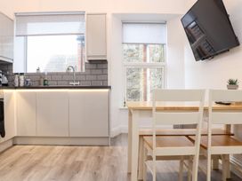 A kitchen with cabinets and a table at Battell Chambers in Camborne