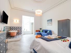 A bedroom with a bed and a bathtub at Mews Retreat in Camborne