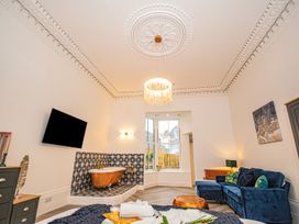 A bathroom with a bathtub and wall-mounted television at Mews Retreat in Camborne