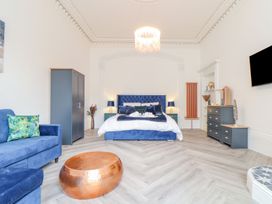 A bedroom with a bed and sofa at Mews Retreat in Camborne