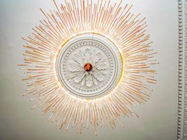 A chandelier with decorative ceiling medallion at Mews Retreat in Camborne