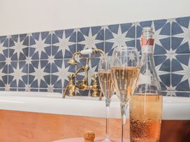 A bathroom with a bathtub and champagne glasses at Mews Retreat in Camborne