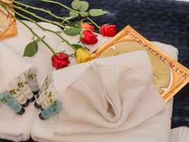 A spa setup with towels, facial masks, and rose flowers at Mews Retreat in Camborne