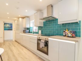 A kitchen with blue tiles and modern appliances at Mews Retreat in Camborne