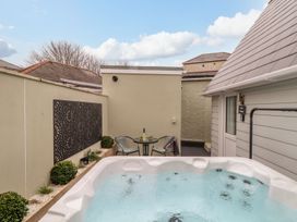 An outdoor area with a hot tub and seating at The Snug in Camborne