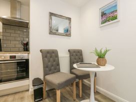 A kitchen with an oven and dining area at The Snug in Camborne
