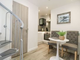 A kitchen with a spiral staircase and seating area at The Snug in Camborne
