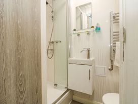 A bathroom with shower, sink, and towel rack at The Snug in Camborne
