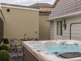 An outdoor area with a hot tub and a table and chairs at The Snug in Camborne