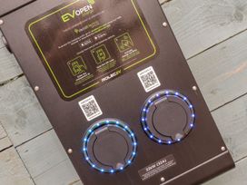 An EV charging point with LED indicators and QR codes at The Snug in Camborne