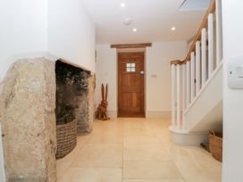 A hallway with a fireplace and a wooden door at Spring View in Tetbury
