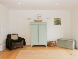 A sitting room with a wardrobe and armchair at Spring View in Tetbury