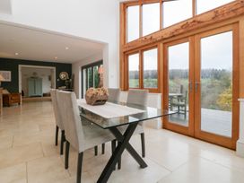 A dining room with a glass table and chairs at Spring View in Tetbury