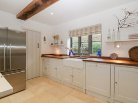 A kitchen with a refrigerator, sink, and cabinets at Spring View in Tetbury