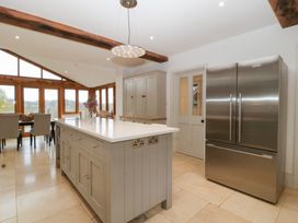 A kitchen with a kitchen island and dining area at Spring View in Tetbury
