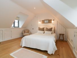 A bedroom with a bed and armchair at Spring View in Tetbury