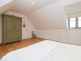 A bedroom with a wardrobe and a small chair at Spring View in Tetbury