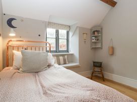 A bedroom with a bed and window at Spring View in Tetbury