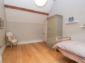 A bedroom with a bed and wardrobe at Spring View in Tetbury