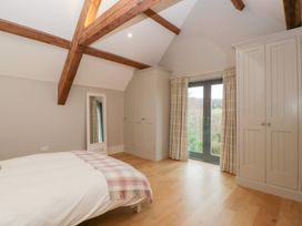 A bedroom with a bed and wardrobe at Spring View in Tetbury