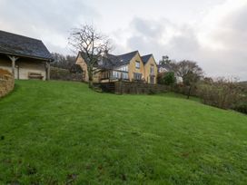 A garden with a house and trees at Spring View in Tetbury
