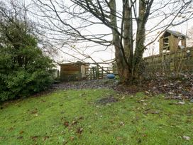 A garden with a tree and shed at Spring View in Tetbury