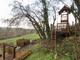 A treehouse in an outdoor area with trees and grass at Spring View in Tetbury